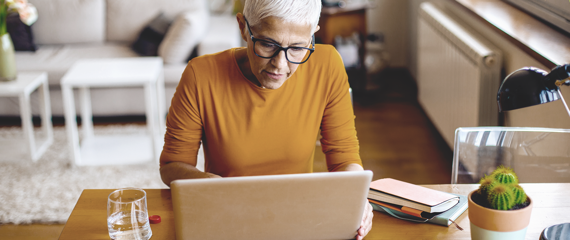 Elderly woman in the living room searches for DBS clinic on the internet with her laptop
