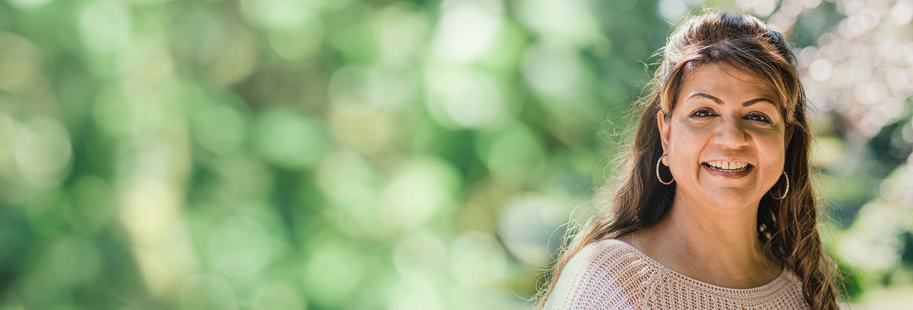 Middle-aged woman smiles thanks to DBS Therapy